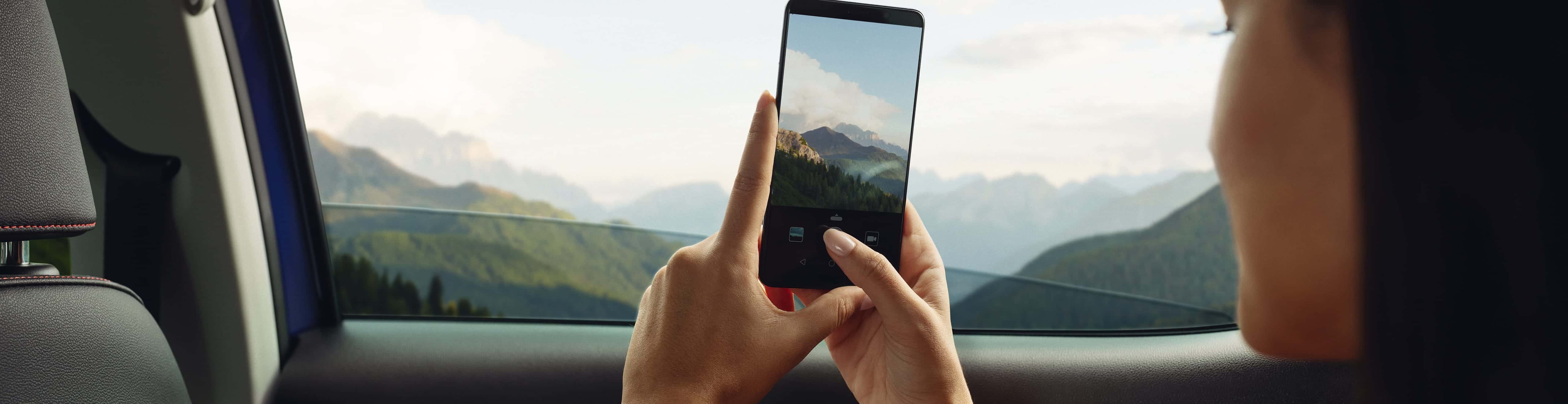 Joven tomando foto con su celular desde un SEAT Arona