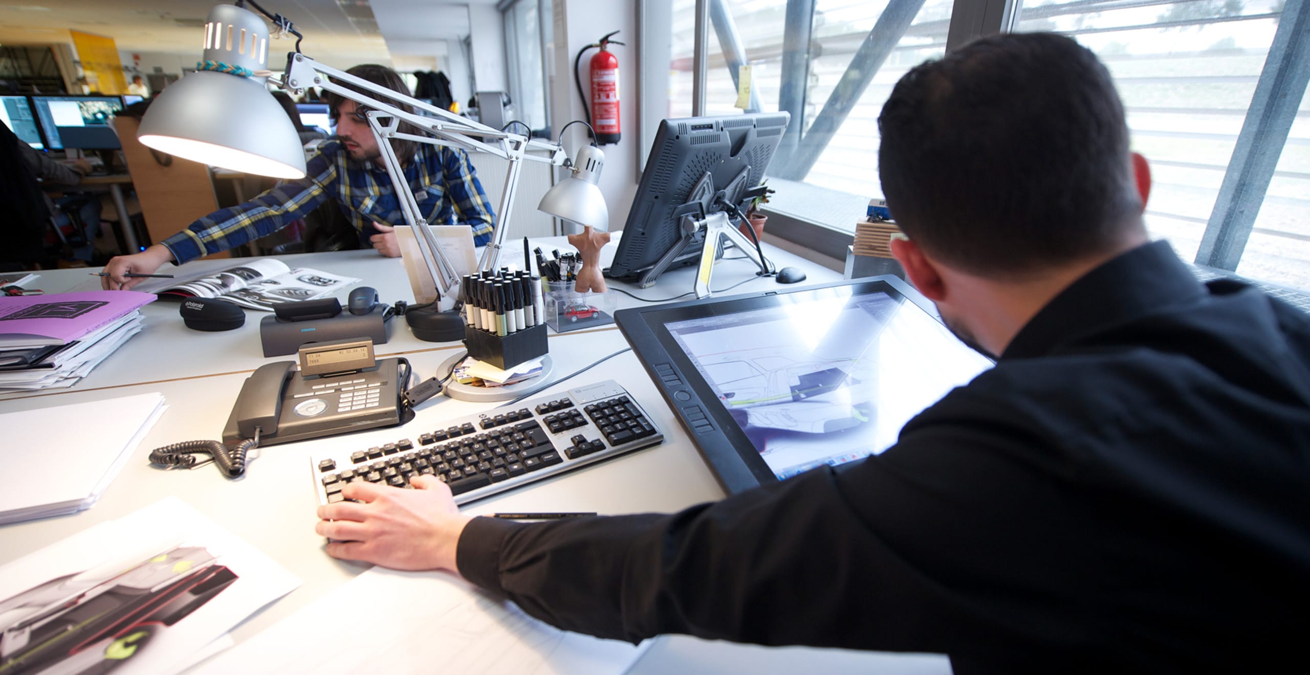 Vista detrás del hombro de un trabajador de escritorio con una tableta inteligente sobre el escritorio - SEAT Human Resources